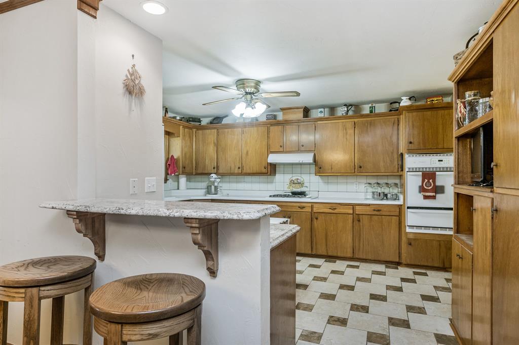 1204 East Cheyenne Avenue Canadian, TX 79014 - Photo 24 of 39 a kitchen with a sink a stove a refrigerator and cabinets