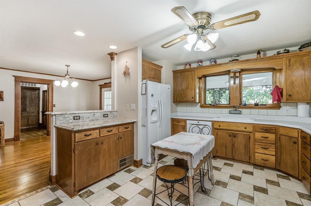 1204 East Cheyenne Avenue Canadian, TX 79014 - Photo 26 of 39 a kitchen with a stove a sink a dining table and chairs