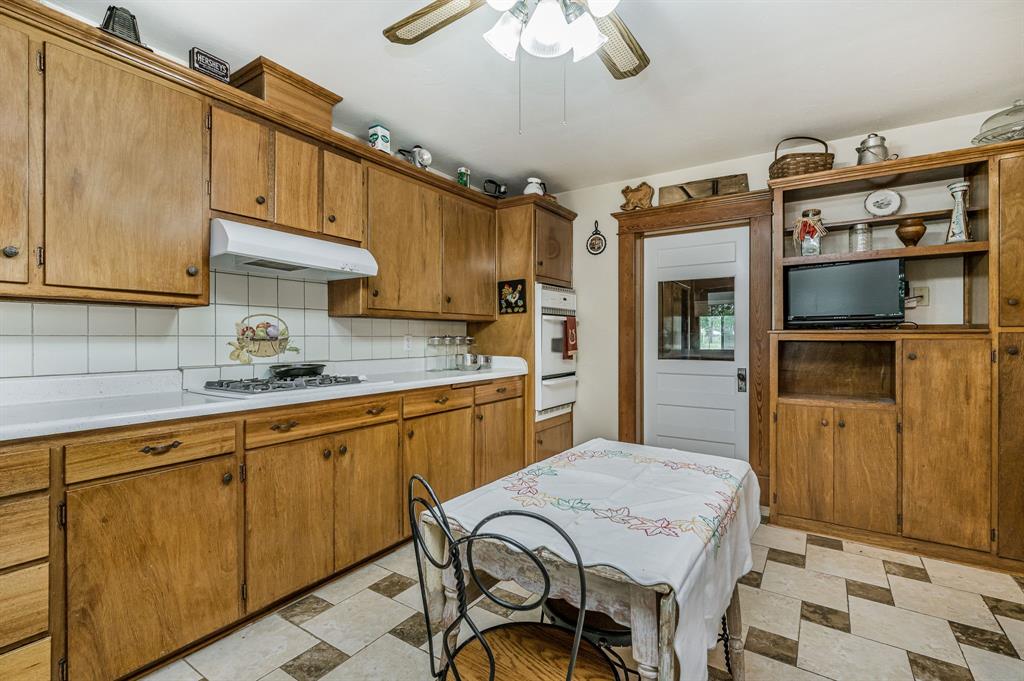 1204 East Cheyenne Avenue Canadian, TX 79014 - Photo 27 of 39 a kitchen with stainless steel appliances granite countertop a sink dishwasher and cabinets with wooden floor