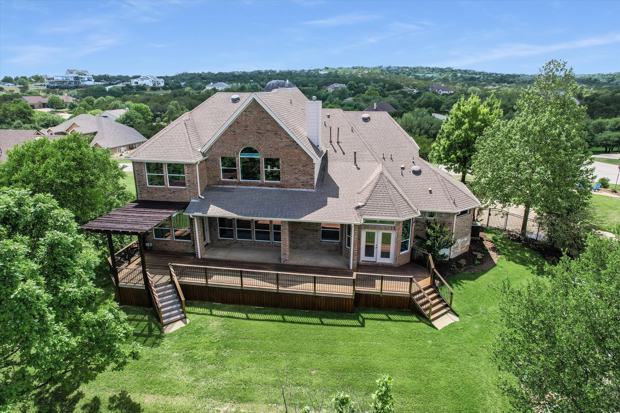 1400 Tom Sawyer Road Austin, TX 78737 - Photo 29 of 40 Expansive rear exterior featuring a multi-level wood deck, covered patio, and pergola