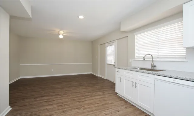 an empty room with wooden floor and window