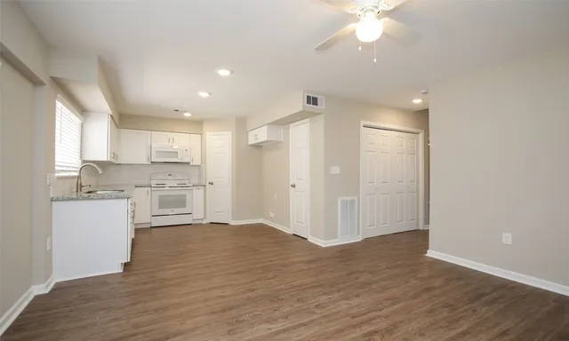 a view of a kitchen with a sink and dishwasher a refrigerator with wooden floor