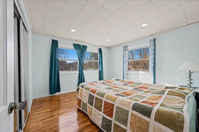 a bedroom with a large bed and a wooden floor