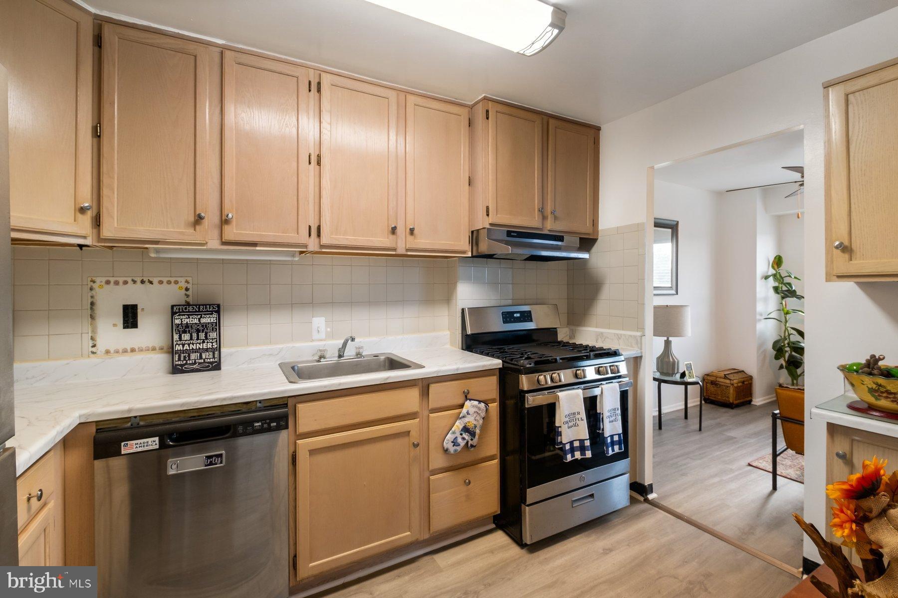 1111 University Boulevard West, Unit 817 Silver Spring, MD 20902 - Photo 12 of 26 a kitchen with stainless steel appliances granite countertop a stove a sink and a white cabinets