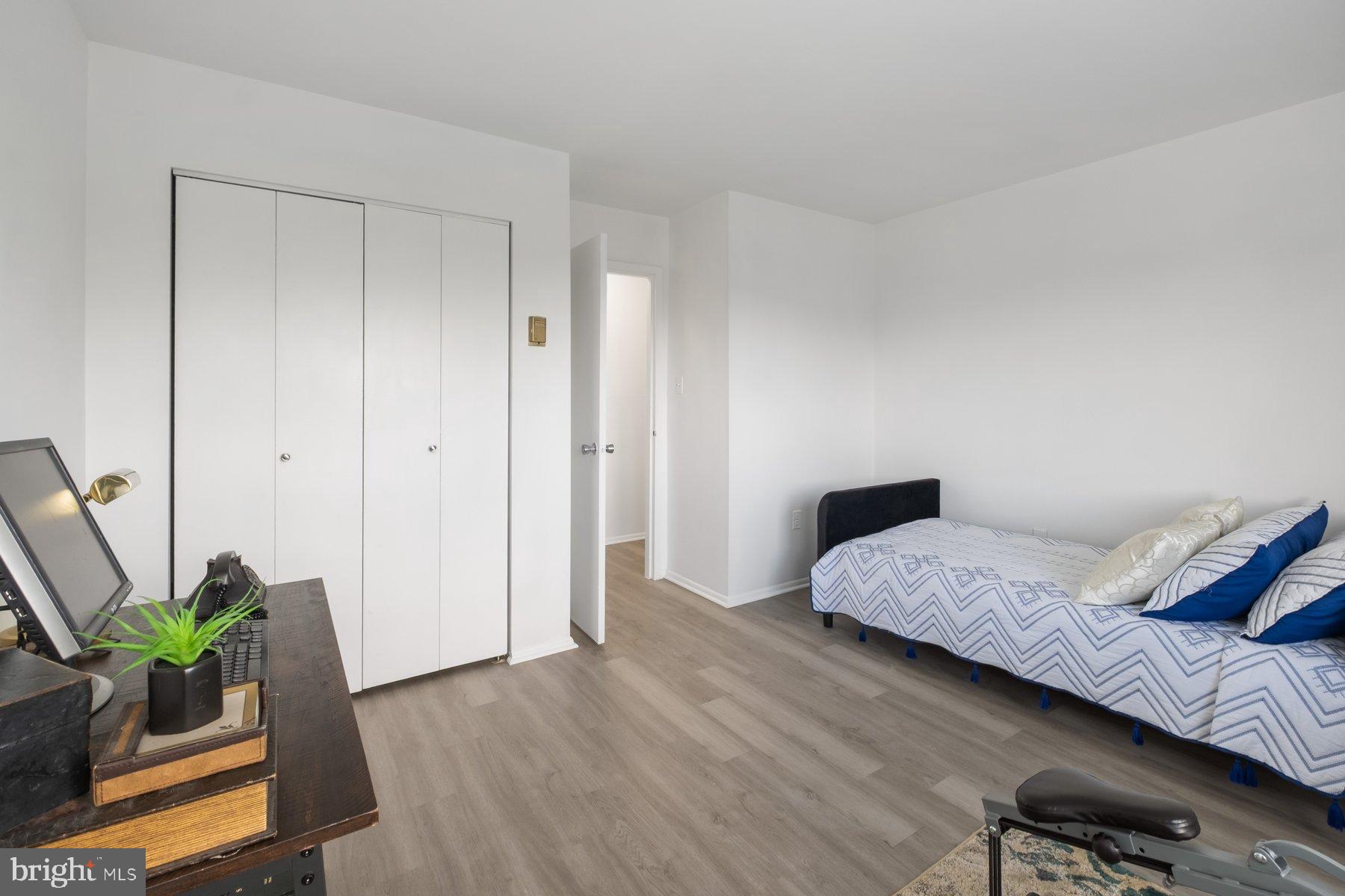 1111 University Boulevard West, Unit 817 Silver Spring, MD 20902 - Photo 15 of 26 a bedroom with a bed and hallway