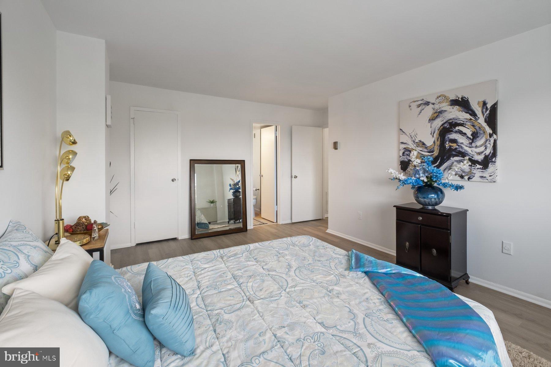 1111 University Boulevard West, Unit 817 Silver Spring, MD 20902 - Photo 19 of 26 a bedroom with a bed and wooden floor