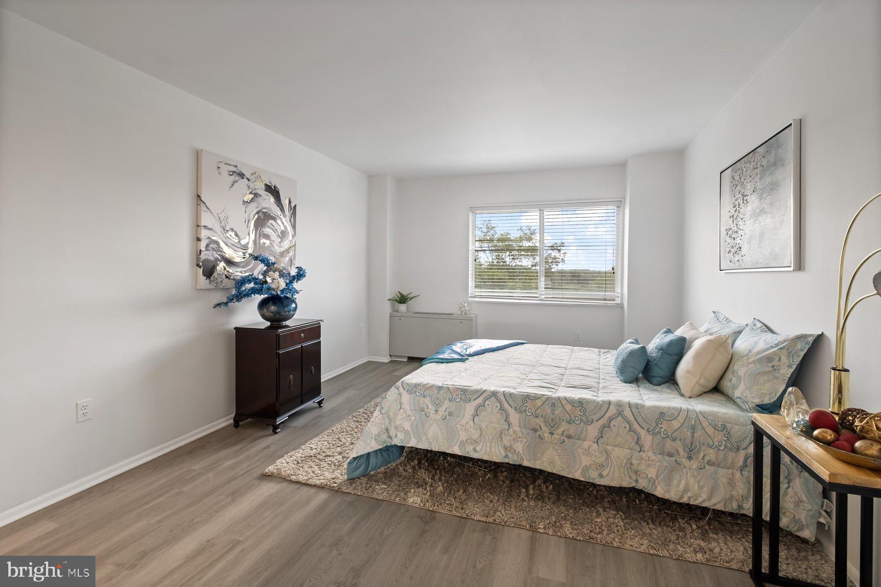 1111 University Boulevard West, Unit 817 Silver Spring, MD 20902 - Photo 22 of 26 a bedroom with a bed and a window