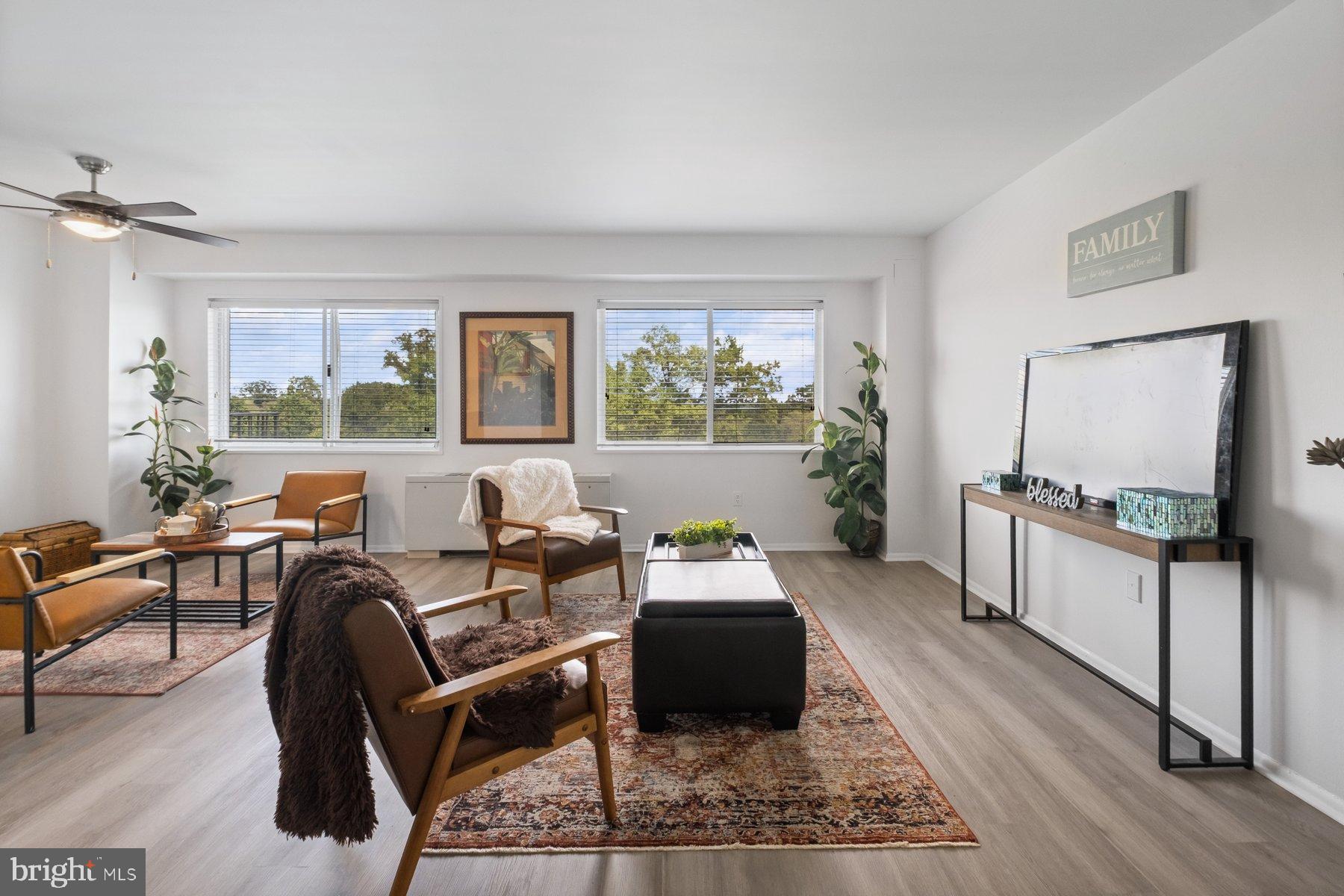 1111 University Boulevard West, Unit 817 Silver Spring, MD 20902 - Photo 24 of 26 a living room with furniture a window and a flat screen tv