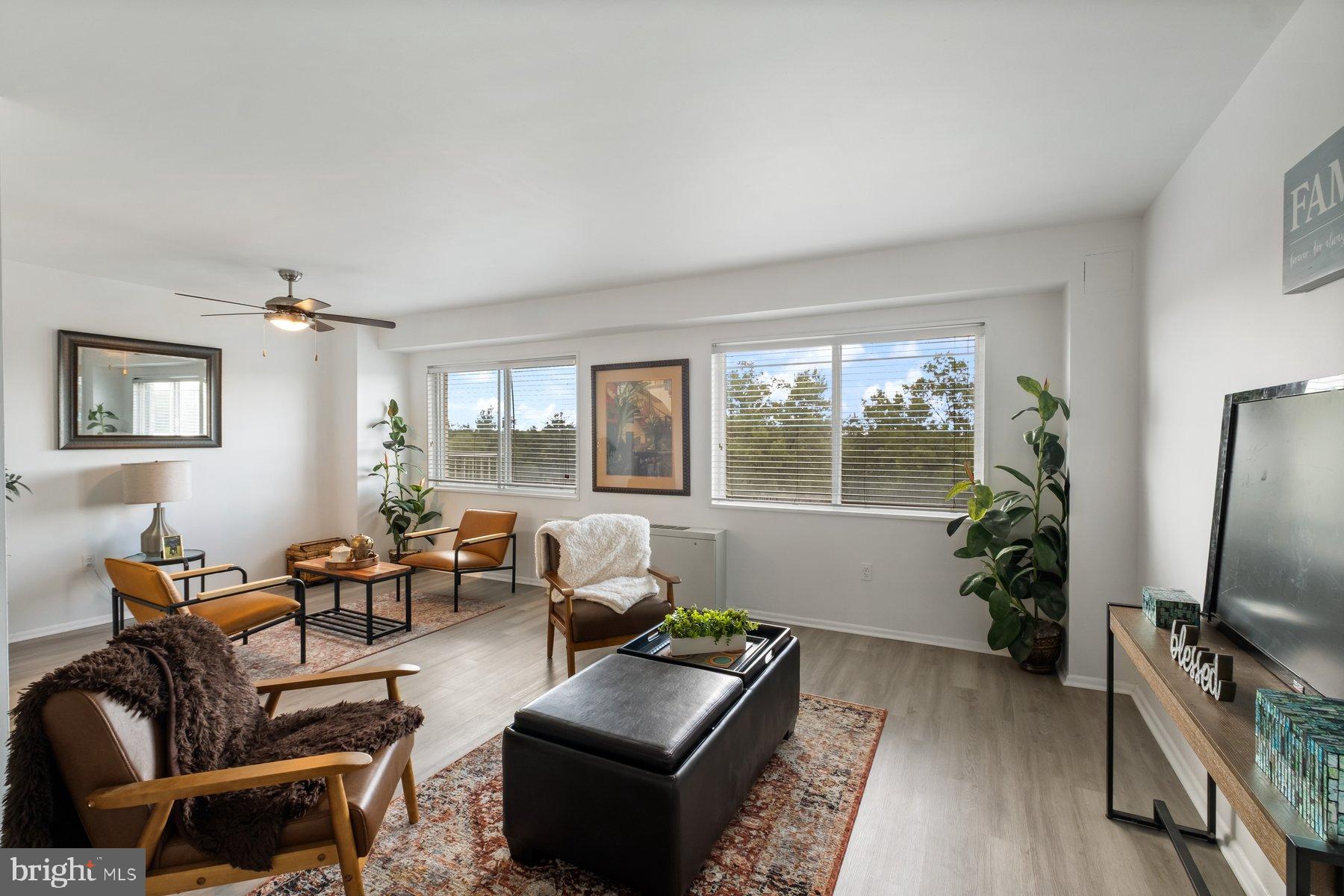 1111 University Boulevard West, Unit 817 Silver Spring, MD 20902 - Photo 7 of 26 a living room with furniture a large window and a flat screen tv