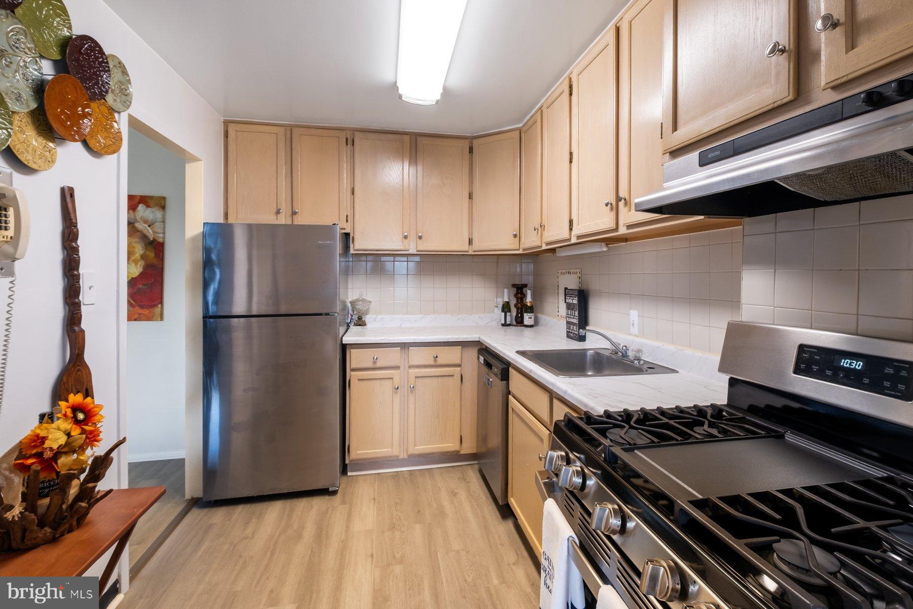 1111 University Boulevard West, Unit 817 Silver Spring, MD 20902 - Photo 10 of 26 a kitchen with a sink stove and refrigerator