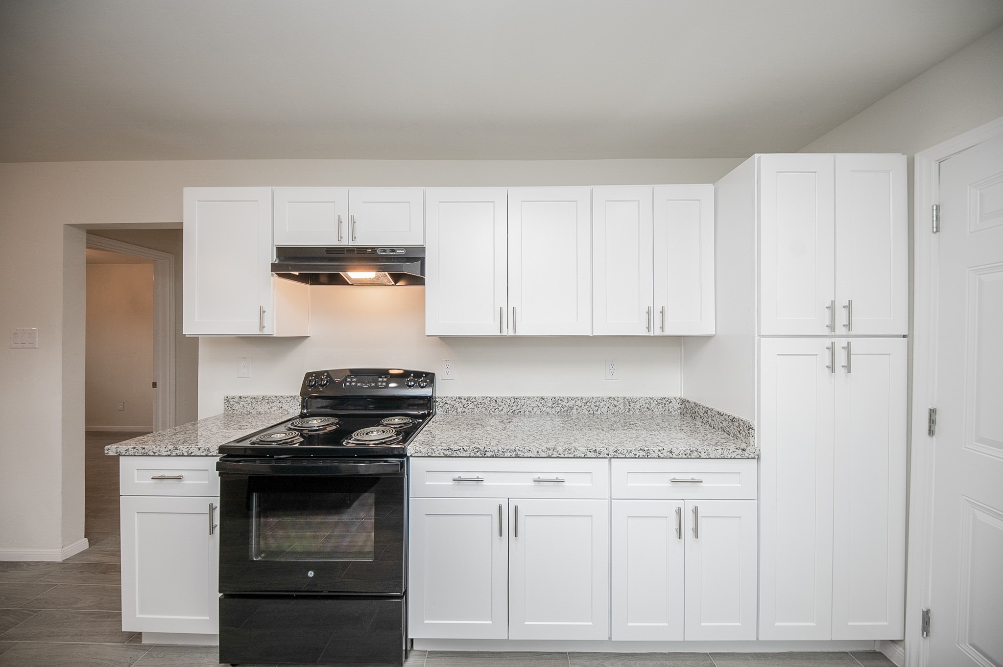 a kitchen with granite countertop white cabinets and stainless steel appliances