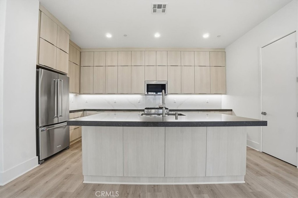 8 Remy Lane Montebello, CA 90640 - Photo 5 of 61 a kitchen with kitchen island granite countertop a sink and a refrigerator