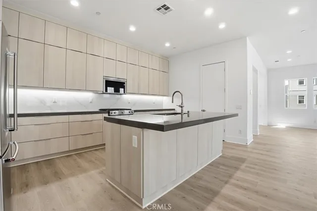 a kitchen with stainless steel appliances granite countertop a stove a sink and a refrigerator