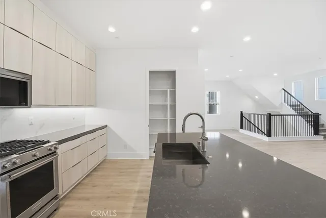 a kitchen with granite countertop a sink stove and refrigerator