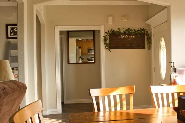 a view of a dining room with wooden floor and a large window