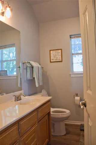 a bathroom with a granite countertop toilet sink and mirror
