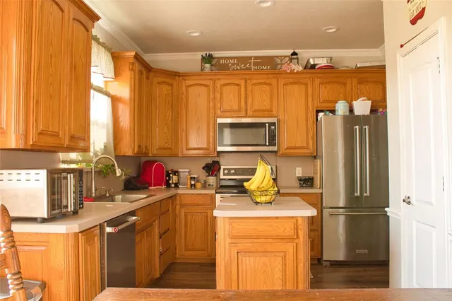 a kitchen with a refrigerator a stove a sink a counter space and a window