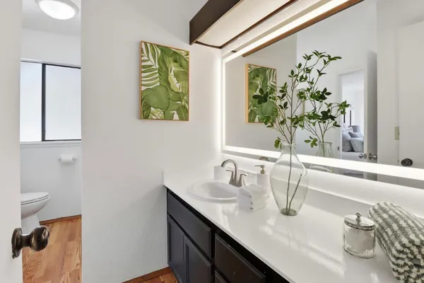 a bathroom with a granite countertop sink a bunch of flowers