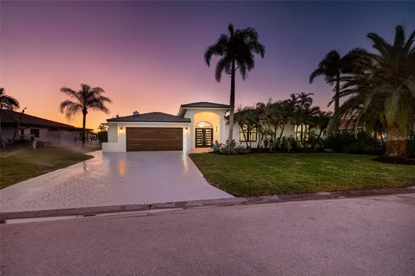 a front view of a house with a yard and palm tree