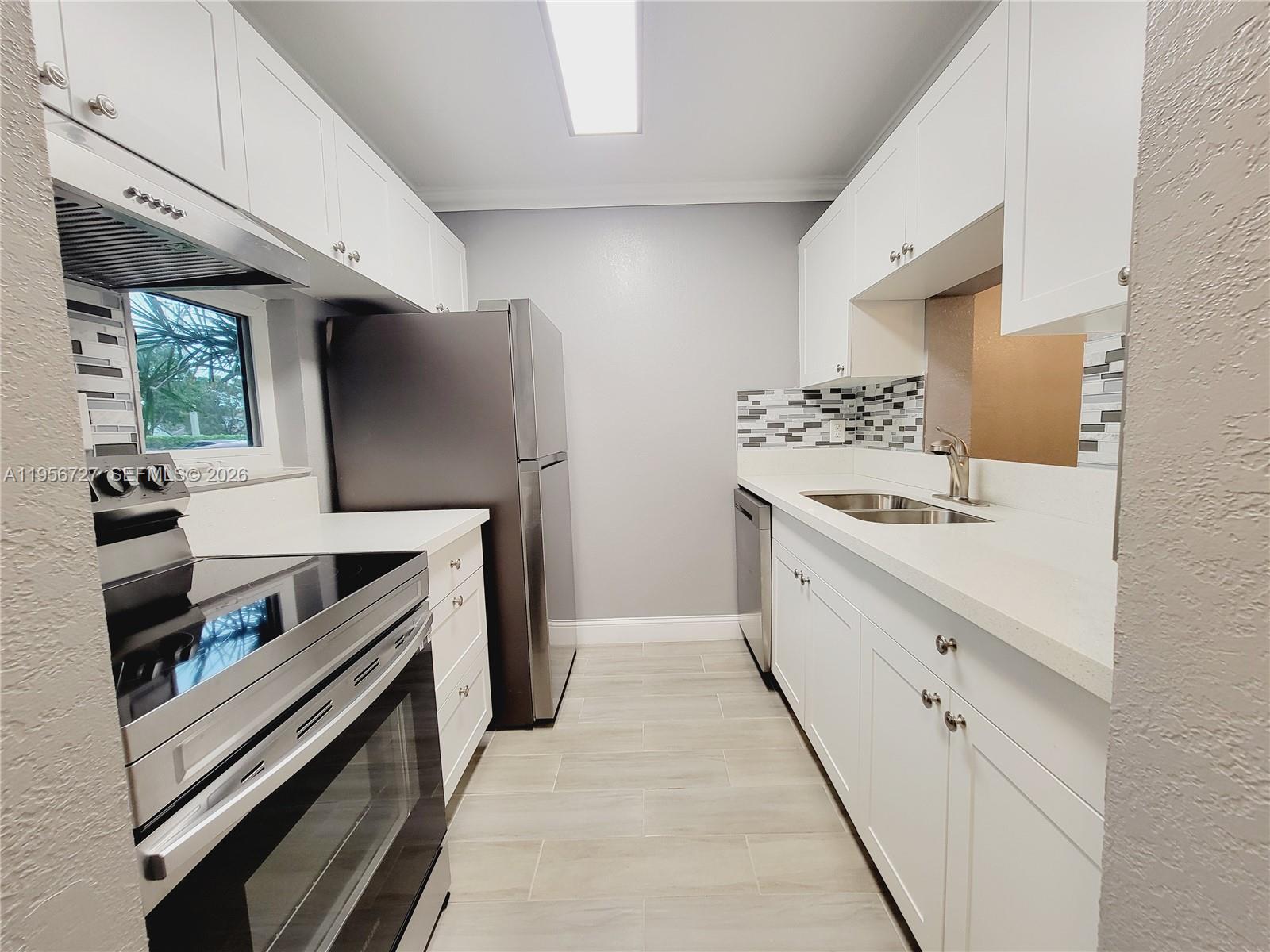 7900 Northwest 50th Street, Unit 108 Lauderhill, FL 33351 - Photo 2 of 18 a kitchen with stainless steel appliances a sink stove and refrigerator