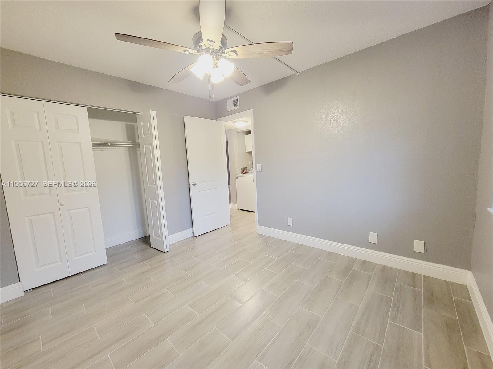 7900 Northwest 50th Street, Unit 108 Lauderhill, FL 33351 - Photo 6 of 18 wooden floor in an empty room with a ceiling fan