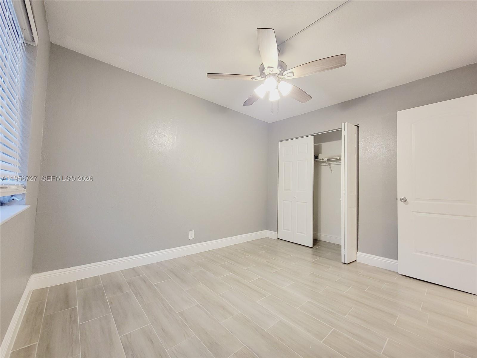 7900 Northwest 50th Street, Unit 108 Lauderhill, FL 33351 - Photo 7 of 18 an empty room with fan and a ceiling fan