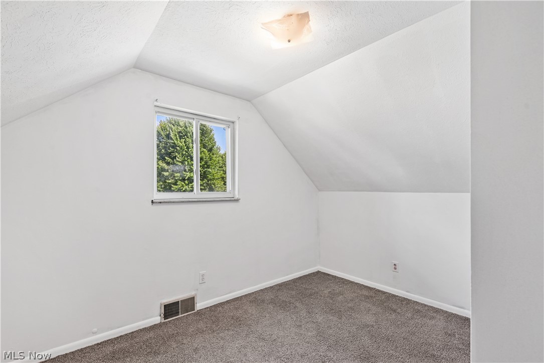 1286 Deforest Road Southeast Warren, OH 44484 - Photo 12 of 27 Room featuring sloped ceilings, white wall paint, and gray carpeting