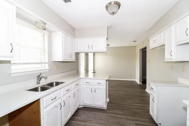 a kitchen with cabinets wooden floor and a sink