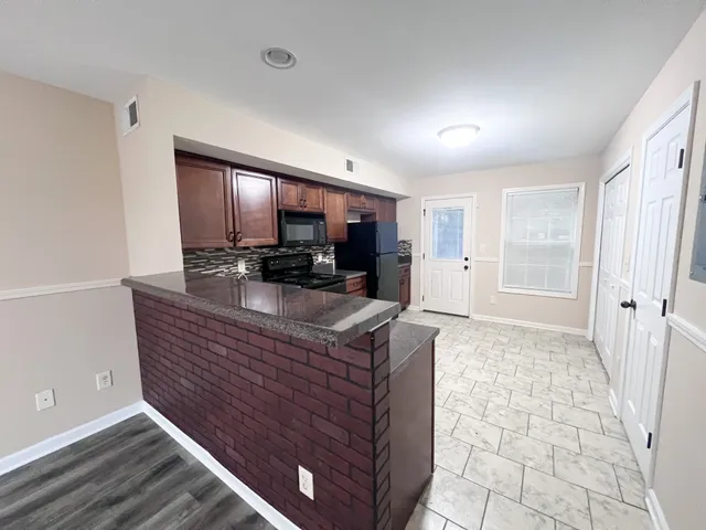 a view of kitchen with stainless steel appliances granite countertop a stove a sink a refrigerator and cabinets