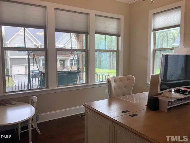 a view of a workspace with furniture and a window