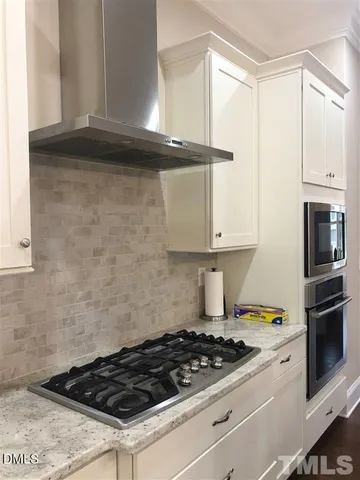 a stove top oven sitting inside of a kitchen