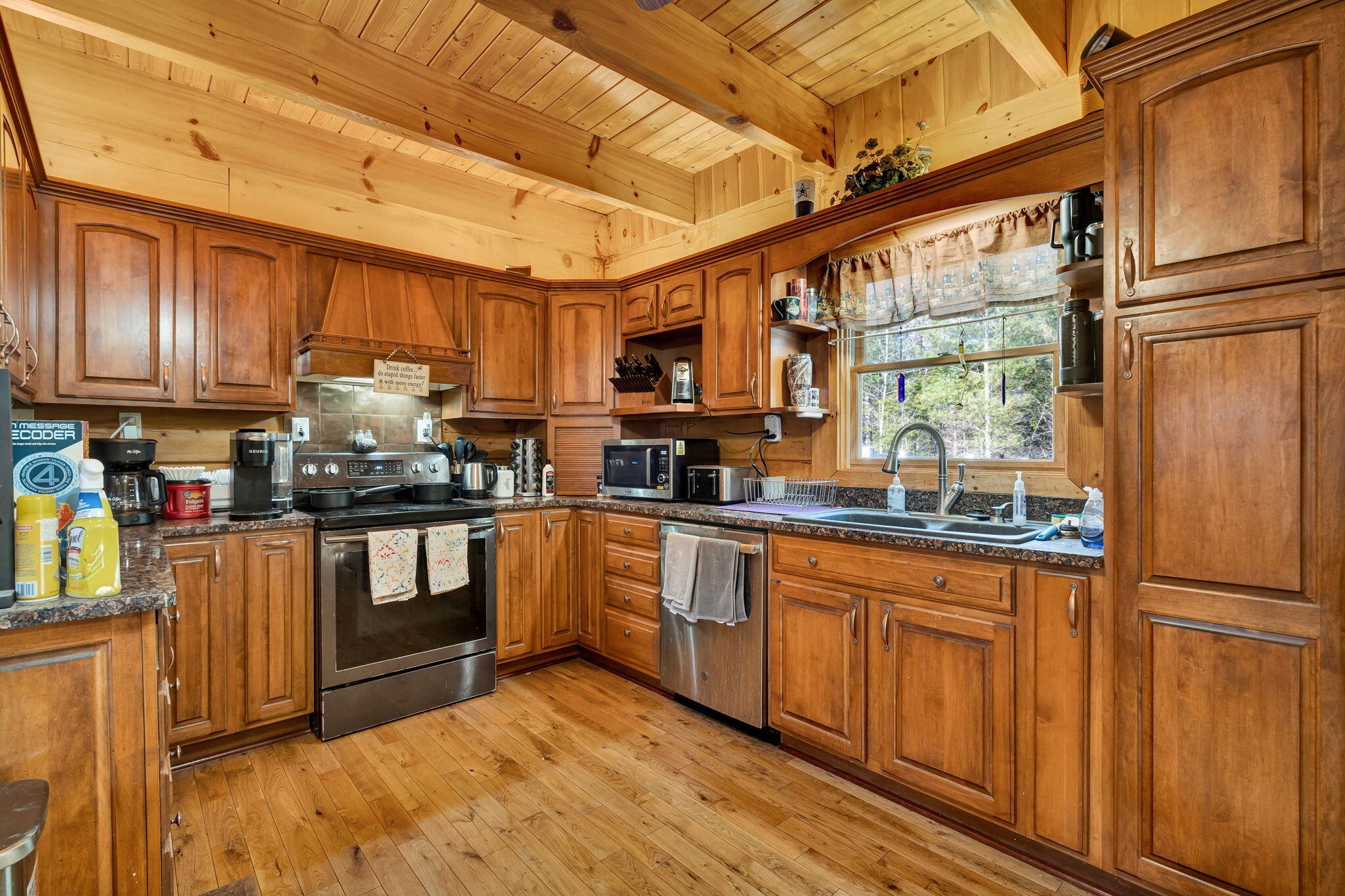 180 McJunkin Road Tellico Plains, TN 37385 - Photo 9 of 60 a kitchen with stainless steel appliances granite countertop a refrigerator a sink dishwasher a stove with wooden cabinets and floor