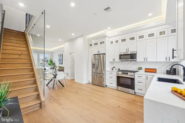 a large white kitchen with stainless steel appliances