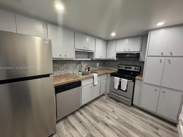 a kitchen with white cabinets and white appliances