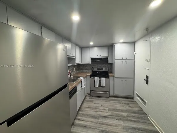 a kitchen with stainless steel appliances a refrigerator and a stove top oven