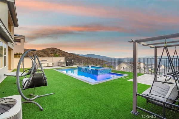 a view of a swimming pool with a lawn chairs and floor to ceiling window