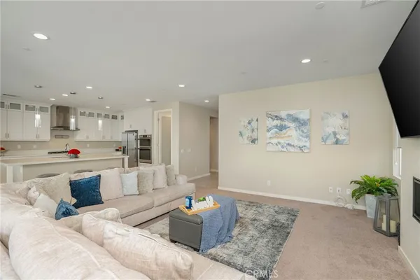 a kitchen with stainless steel appliances granite countertop a sink a stove a refrigerator and white cabinets