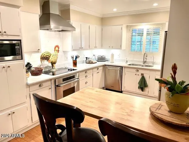 a kitchen with stainless steel appliances kitchen island granite countertop a table chairs sink and cabinets