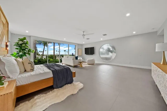a bedroom with a large bed couch and a large window