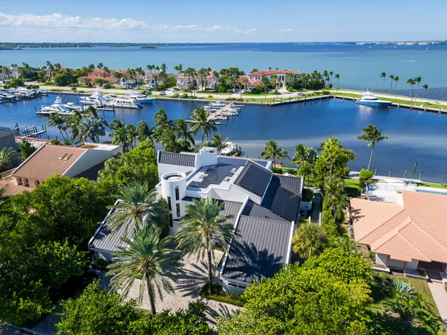 an aerial view of residential houses with outdoor space and ocean view