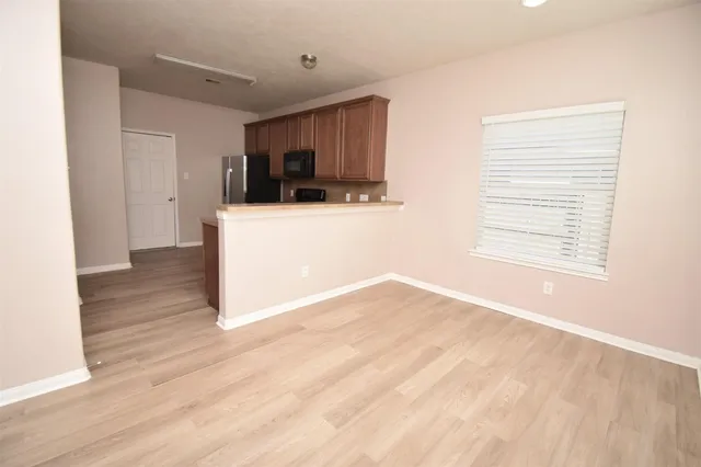 a view of a room with wooden floor and a window