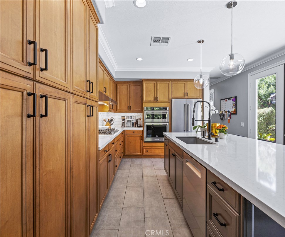 45 Coriander Irvine, CA 92603 - Photo 40 of 64 a kitchen with stainless steel appliances granite countertop a sink a counter space cabinets and a window