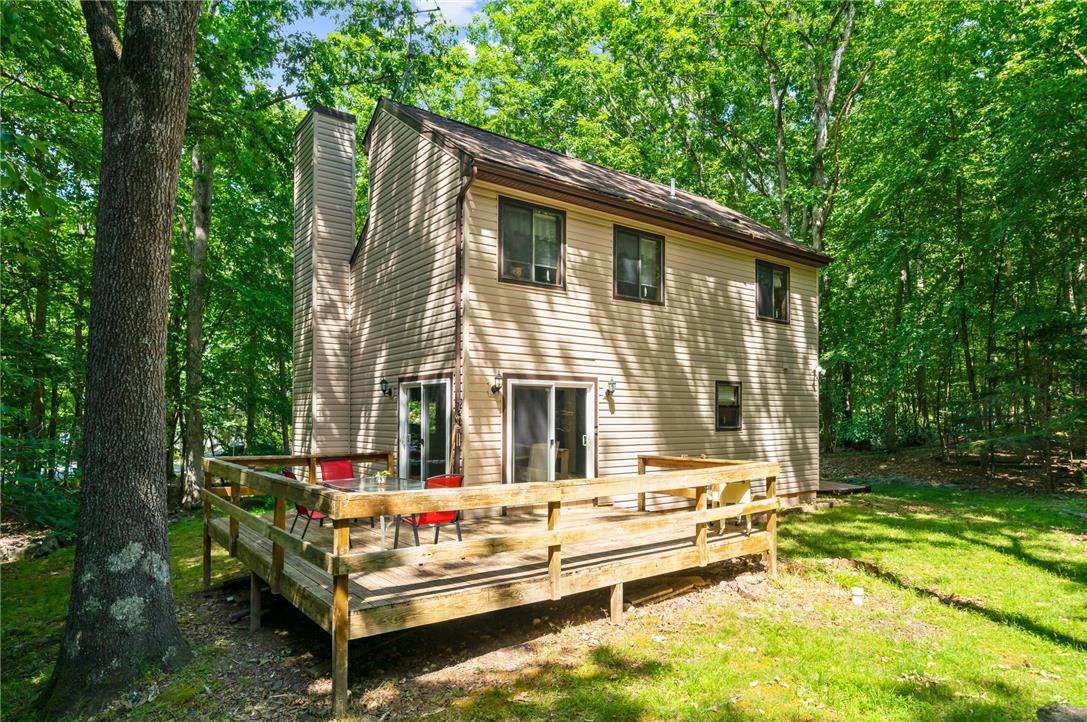 222 Powder Horn Road Henryville, PA 18332 - Photo 18 of 25 A spacious outdoor deck with sliding glass doors offers a serene connection to the surrounding wooded landscape.