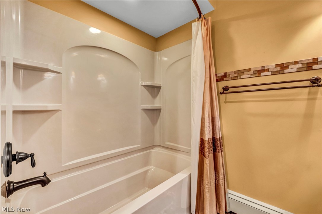 6845 Liberty Road Solon, OH 44139 - Photo 34 of 47 Tub and shower combination featuring integrated shelving and an arched alcove
