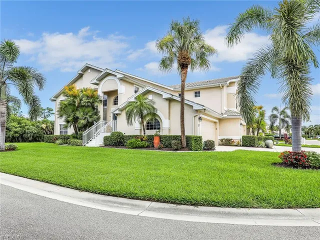 a front view of a house with a garden and trees