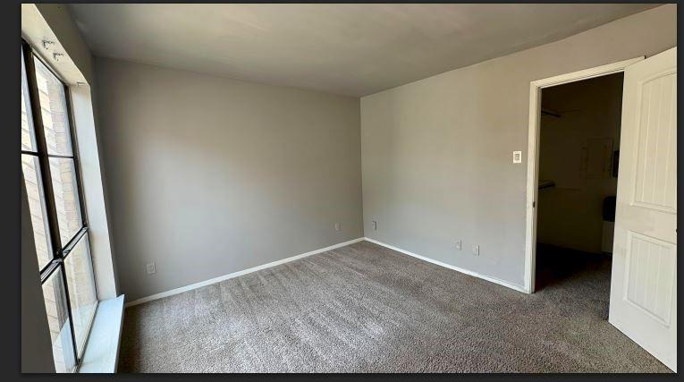8110 Skillman Street, Unit 2057 Dallas, TX 75231 - Photo 7 of 16 Unfurnished bedroom with carpet flooring and a spacious closet