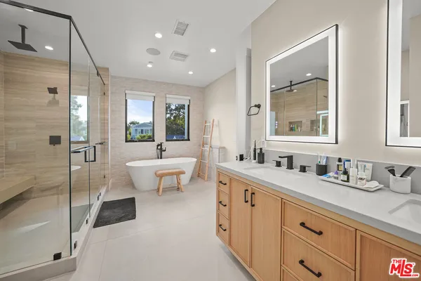 a spacious bathroom with a double vanity sink toilet mirror and bathtub