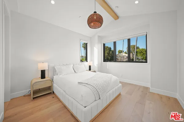 a bedroom with a large bed and a chandelier