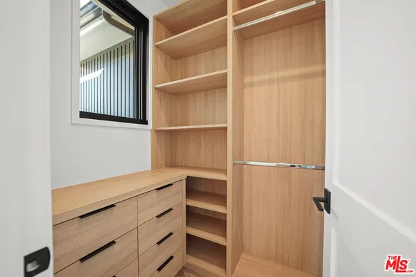 a view of walk in closet with empty racks