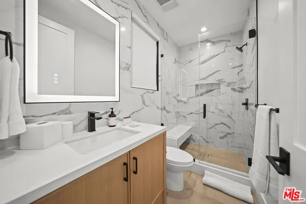 a bathroom with a sink a toilet and shower